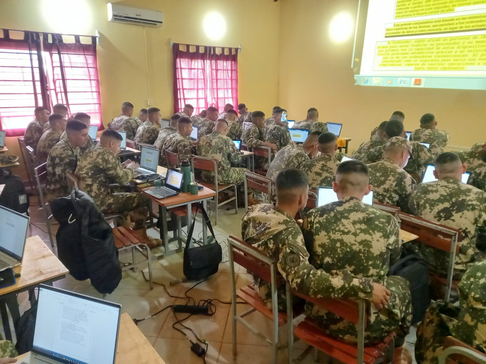 Alumnos de la Escuela de Material Bélico durante una actividad de capacitación en aula con equipos informáticos.